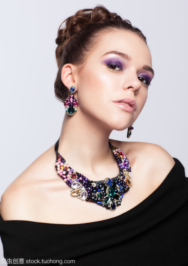 珠寶首飾在灰色的背景上的棕色頭發(fā)年輕女子